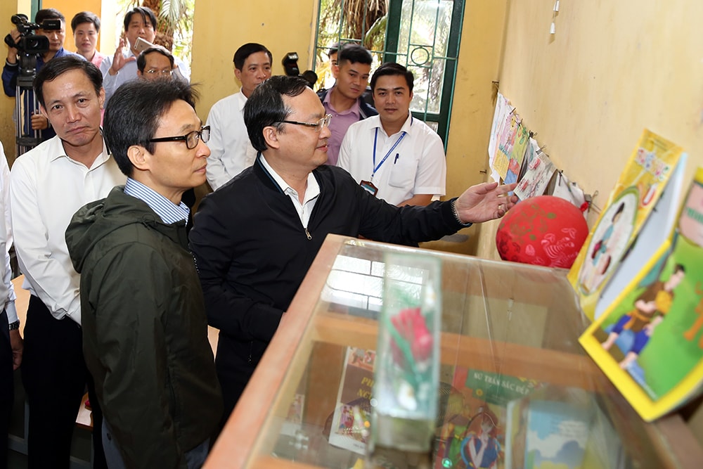 Phó Thủ tướng Vũ Đức Đam và Bí thư Tỉnh uỷ Hưng Yên Đỗ Tiến Sỹ thăm một tủ sách lớp em ở trường tiểu học Dạ Trạch. Ảnh: VGP