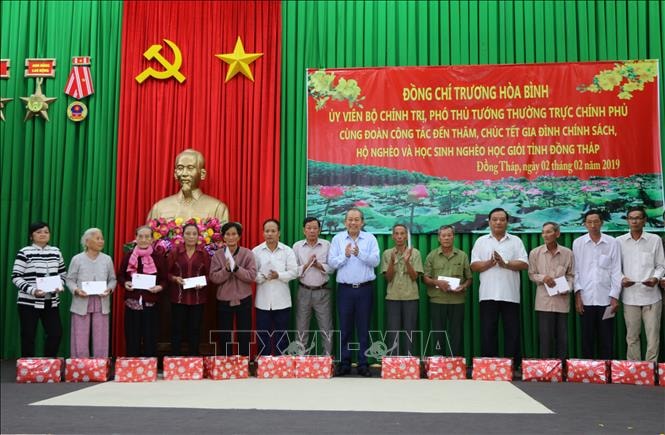 Phó Thủ tướng Thường trực Chính phủ Trương Hòa Bình tặng quà cho gia đình chính sách, hộ nghèo. Ảnh: TTXVN