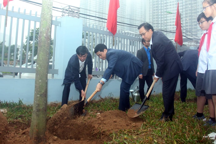 Các đại biểu trồng cây xanh trong khuôn viên Trường THCS Cầu Diễn. Ảnh: HNM