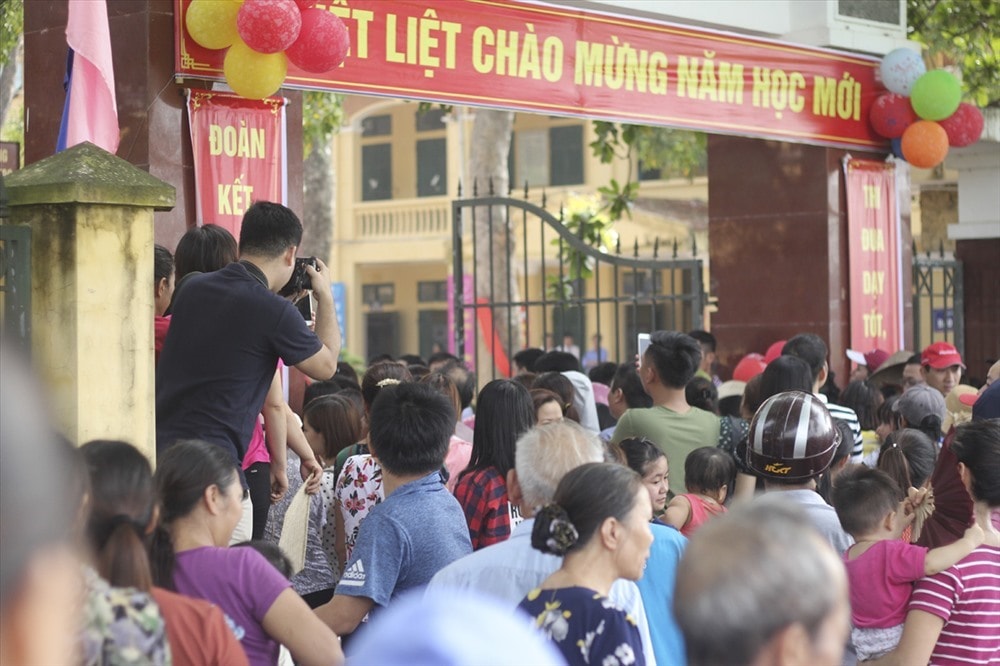 Phụ huynh học sinh Trường Tiểu học Sơn Đồng đứng ngoài cổng trường theo dõi lễ khai giảng của con vào sáng 5/9. Ảnh minh họa.