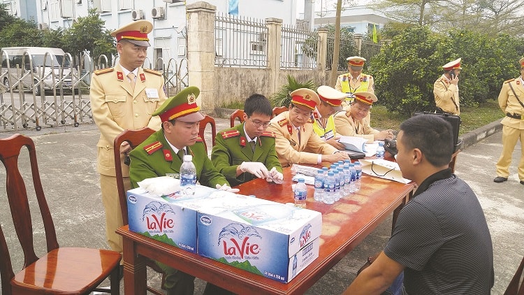 Các cán bộ của Viện Khoa học Hình sự, Bộ Công an tiến hành xét nghiệm mẫu nước tiểu của lái xe. Ảnh: Vũ Lân