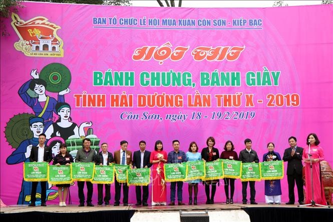 Ban tổ chức trao cờ lưu niệm cho các đội dự hội thi bánh chưng, bánh giầy. Ảnh: Mạnh Tú/TTXVN