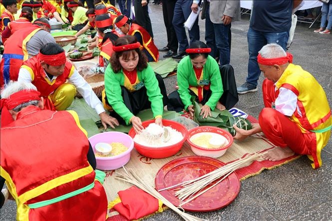 Các nghệ nhân thi gói bánh chưng. Ảnh: Mạnh Tú/TTXVN
