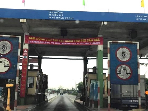 Băng rôn treo trên cổng trạm thu phí Cầu Rác thông báo tạm dừng thu phí. Ảnh PV