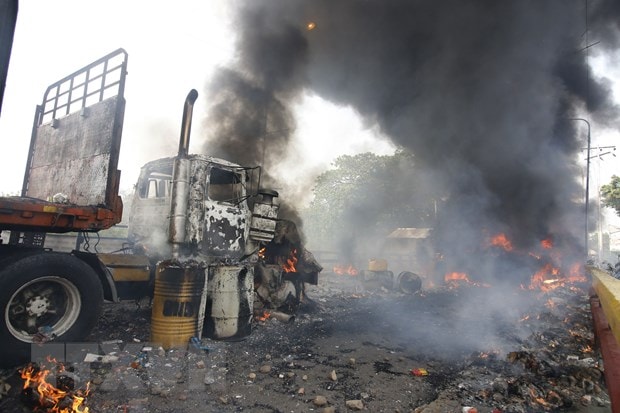 Xe tải chở hàng nhân đạo bị đốt tại khu vực biên giới giữa Venezuela và Colombia ngày 23/2. Ảnh: AFP
