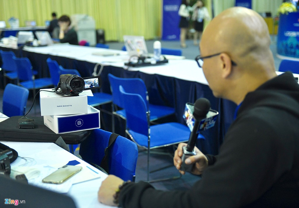 Anh Lan Vu, phóng viên của một trang tin cho cộng đồng người Việt tại Mỹ, tự đặt máy quay và tường thuật không khí tại trung tâm báo chí khi Tổng thống Trump đáp xuống Hà Nội. Anh cho biết cách làm việc thế này khá hiệu quả khi có ít người, nhưng anh lại không thể theo được hết các sự kiện. Vì vậy anh phải chọn lọc những sự kiện hợp lý để đưa tin. Ảnh: Quỳnh Trang.