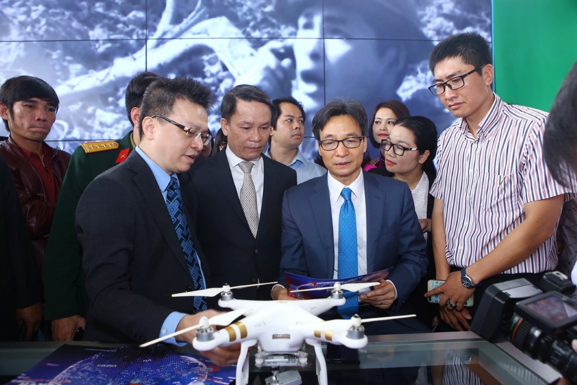 Nhà báo Lê Quốc Minh (bên trái) đang giới thiệu gian trưng bày của Thông Tấn Xã Việt Nam với Phó Thủ tướng Vũ Đức Đam tại Hội báo Toàn quốc 2018.