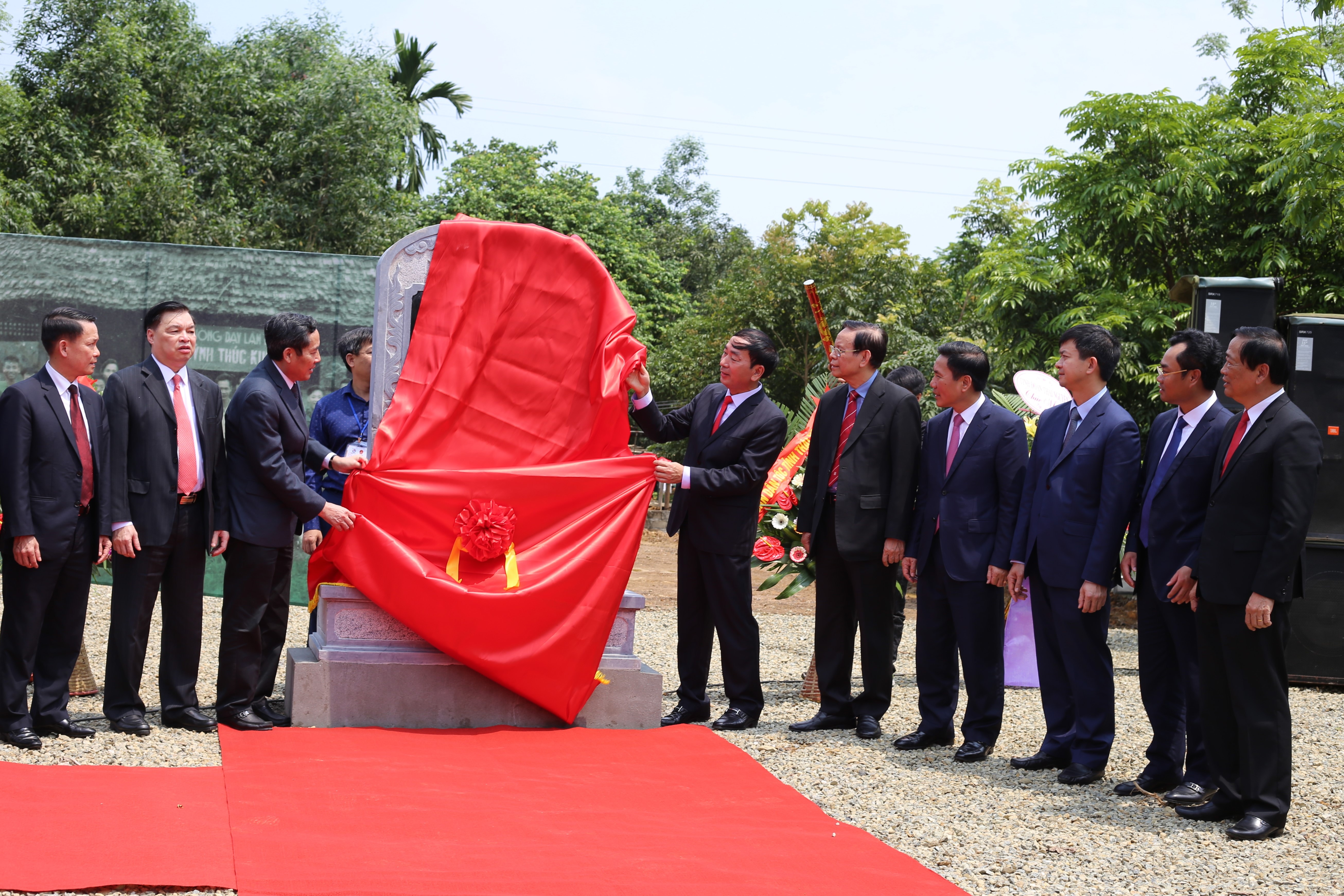 Các vị đại biểu đã cùng nhau kéo băng khánh thành Bia Di tích lịch sử quốc gia-Trường dạy làm báo Huỳnh Thúc Kháng.
