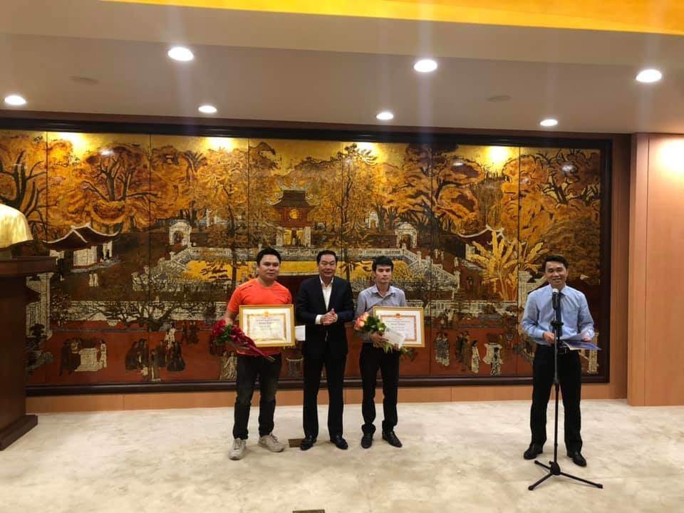 Lãnh đạo thành phố Hà Nội tặng bằng khen cho PV Chu Văn Lương (phải) và Đỗ Văn Trụ (trái)