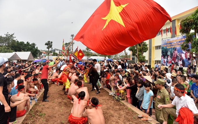 Trong tiếng trống hội rộn rã, tiếng hò reo cổ vũ cả dân làng, trai tráng khoẻ mạnh nhanh tay ra sức kéo cây song. Ảnh: Báo Nhandan