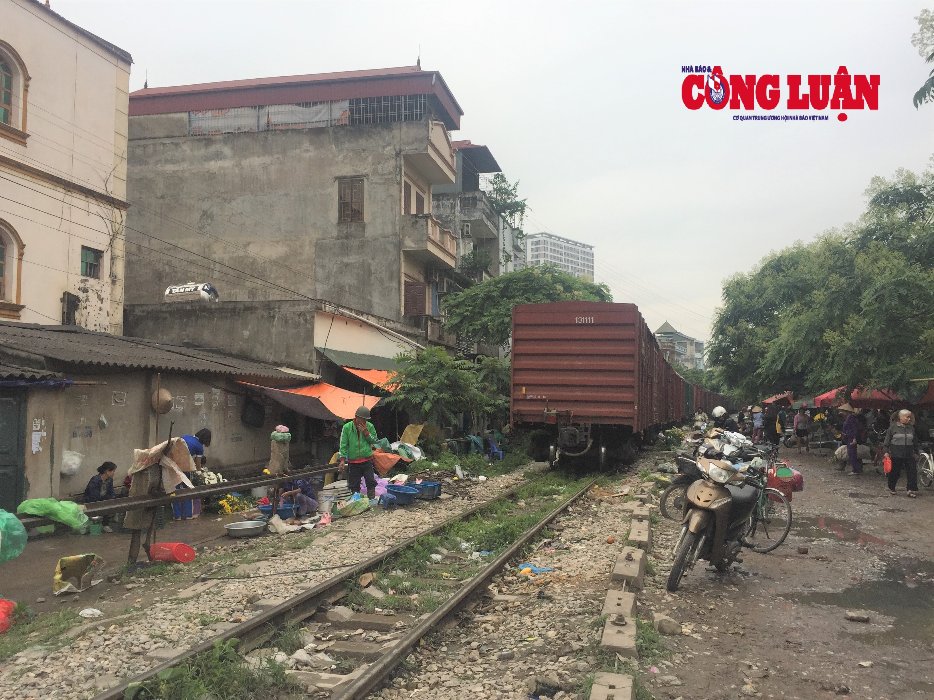 Tiểu thương vội vàng thu dọn hàng hóa khi tàu chạy qua