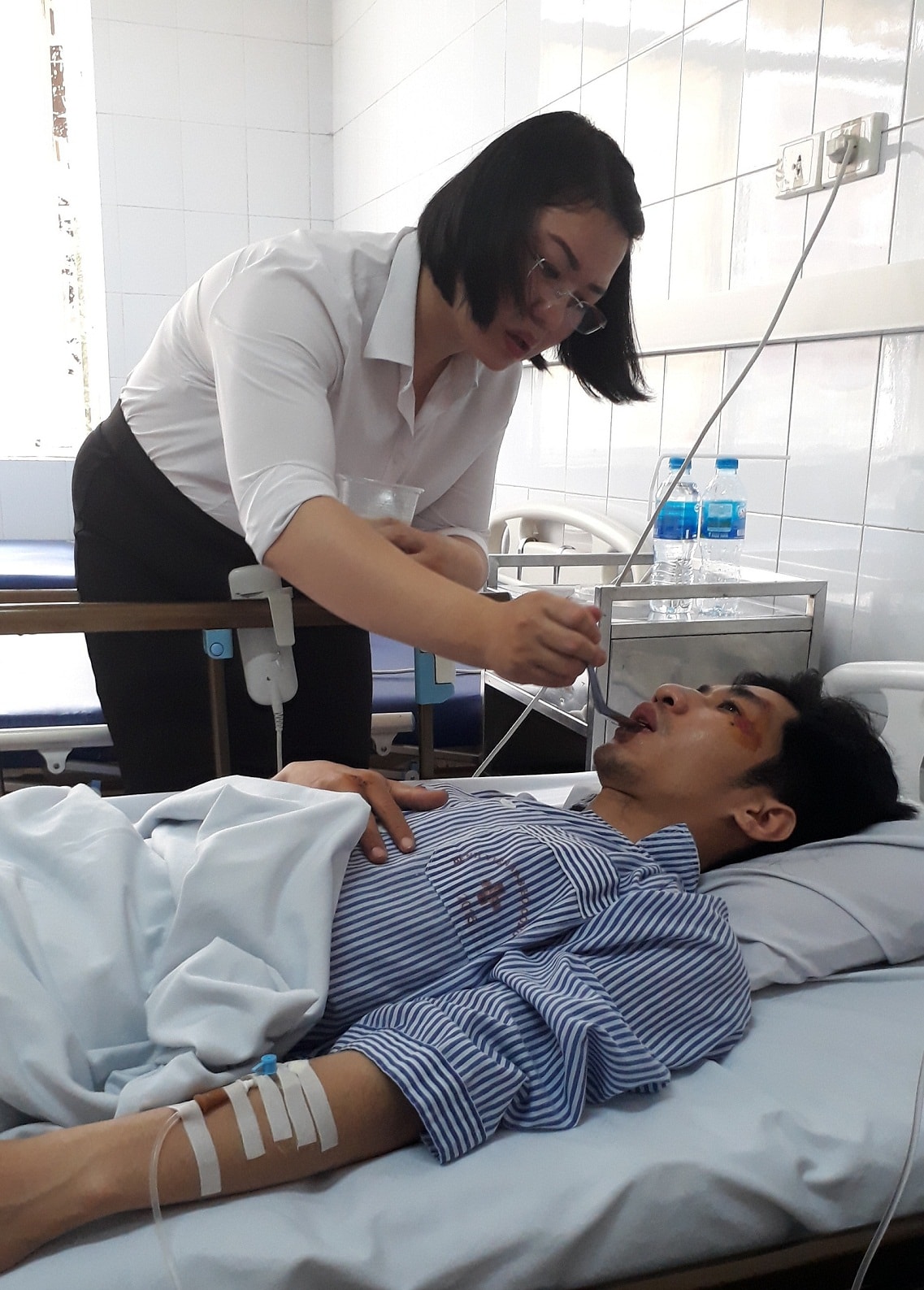 Chị S. – người nhà của nữ tài xế H. đang chăm sóc anh Trần Trung M. (Hà Nội). Hiện sức khỏe của anh dần ổn định trở lại, anh đã có thể tự mình di chuyển nhẹ nhàng. Ảnh: QT