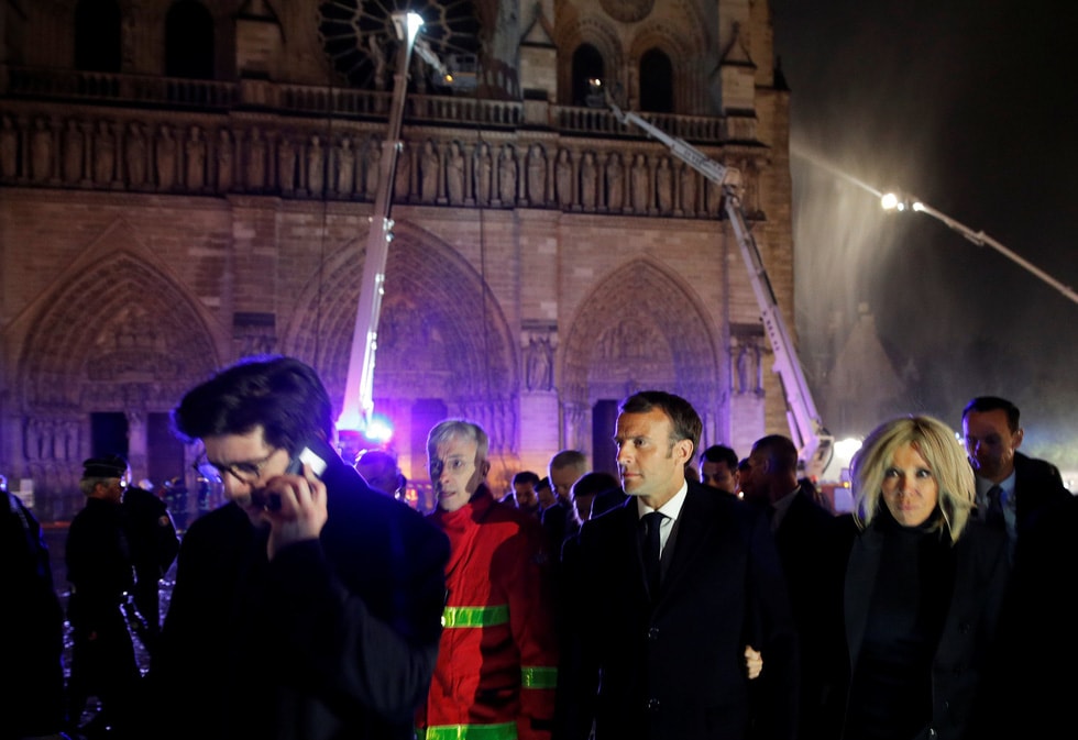 Tổng thống Pháp Emmanuel Macron cùng vợ, bà Brigitte, tới hiện trường vụ cháy nhà thờ ngày 15-4 - Ảnh: REUTERS