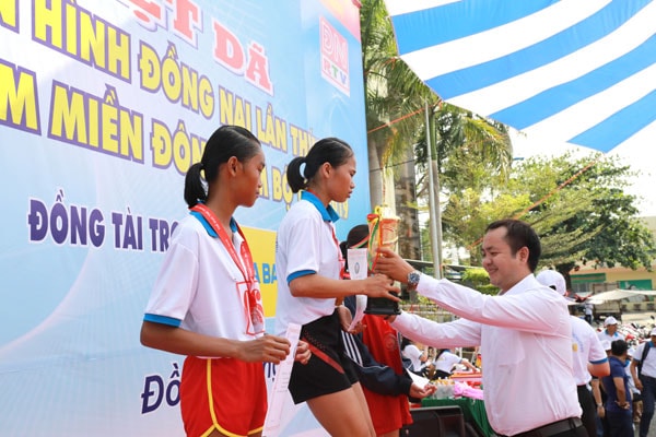 Đại diện nhãn hàng nước uống vận động Number 1 Active Chanh Muối trao cup vàng VĐV Lã Thị Tuyết Hoa (Bình Phước) giành hạng Nhất nội dung 4km nữ hệ mở rộng