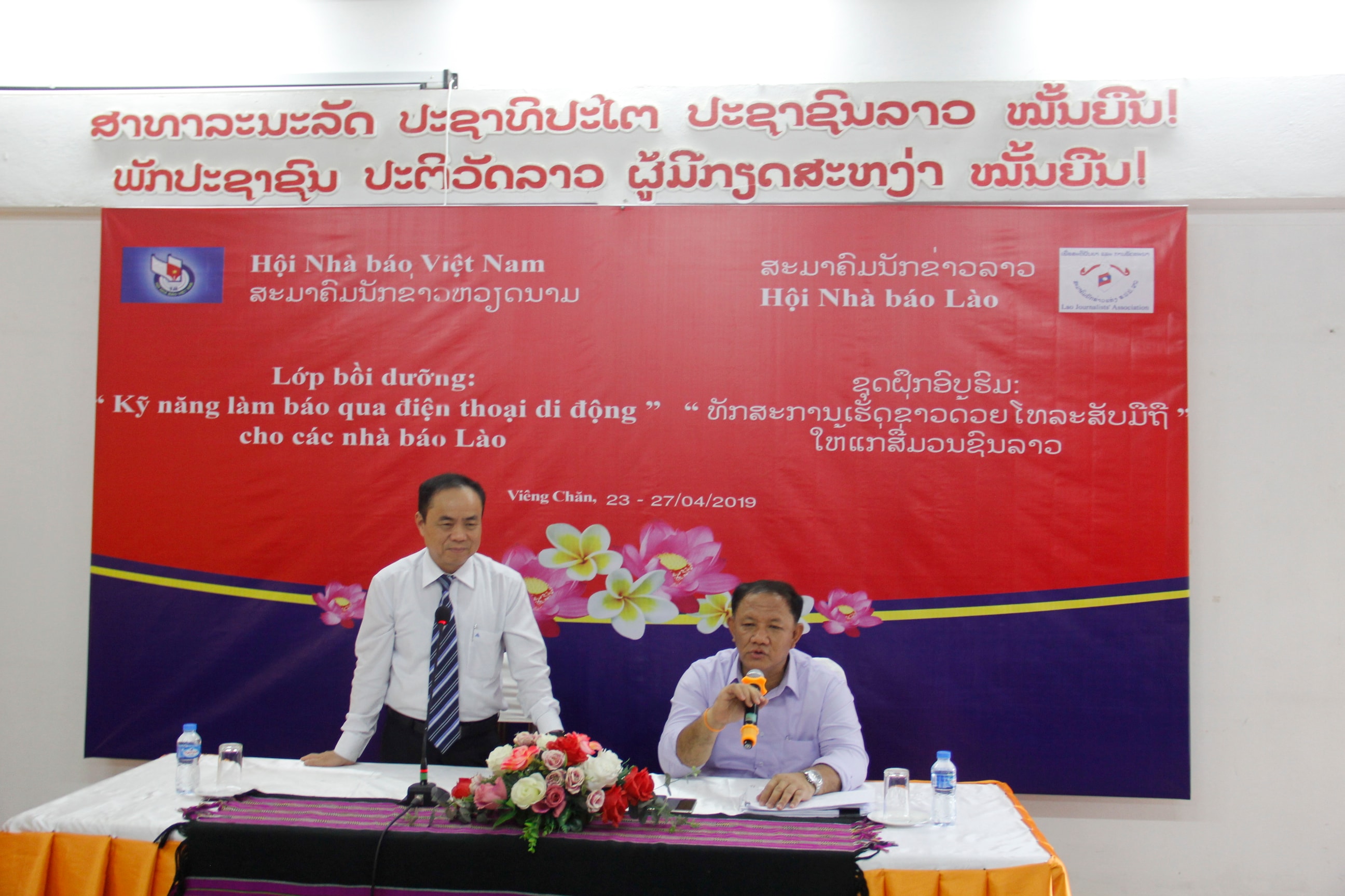 Tiến sĩ Trần Bá Dung, Ủy viên Thường vụ, Trưởng Ban Nghiệp vụ Hội Nhà báo Việt Nam (bên trái) phát biểu tại lễ khai giảng. Ảnh: Hòa Mi