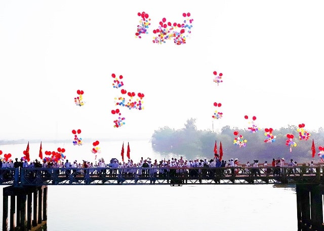 Đoàn đại biểu do Ủy viên Bộ Chính trị, Phó Thủ tướng Thường trực Chính Phủ Trương Hòa Bình dẫn đầu đứng giữa cầu Hiền Lương thả bóng bay, thể hiện ý nghĩa hợp nhất, thống nhất hai miền Nam, Bắc. Ảnh: Báo nhandan