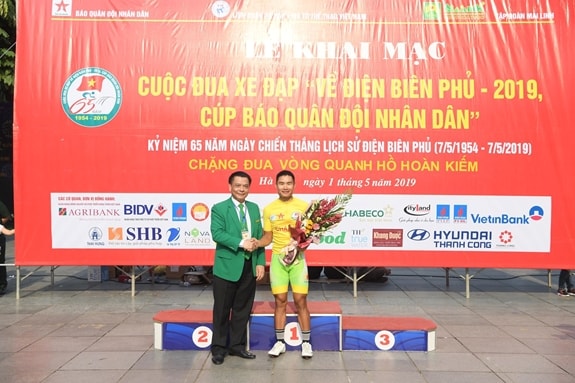 Đồng chí Hồ Huy - Chủ tịch Hội đồng quản trị Tập đoàn Mai Linh trao áo vàng tặng tay đua Quàng Văn Cường. Ảnh: Báo qdnd