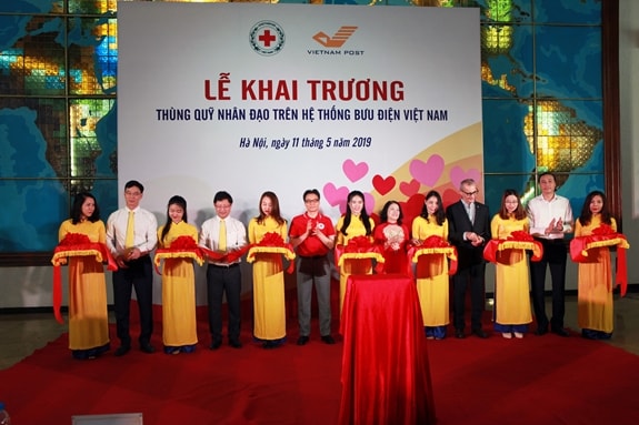 Phó Thủ tướng Vũ Đức Đam và các đại biểu cắt băng khai trương Thùng quỹ nhân đạo trên hệ thống Bưu điện Việt Nam. Ảnh: Báo qdnd