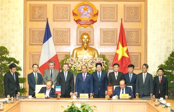 Bộ trưởng, Chủ nhiệm Văn phòng Chính phủ Mai Tiến Dũng (bên phải) và ông Jean-Pierre Marcelli, Giám đốc điều hành AFD ký kết Bản ghi nhớ hợp tác trước sự chứng kiến của Thủ tướng Nguyễn Xuân Phúc. Ảnh: VGP
