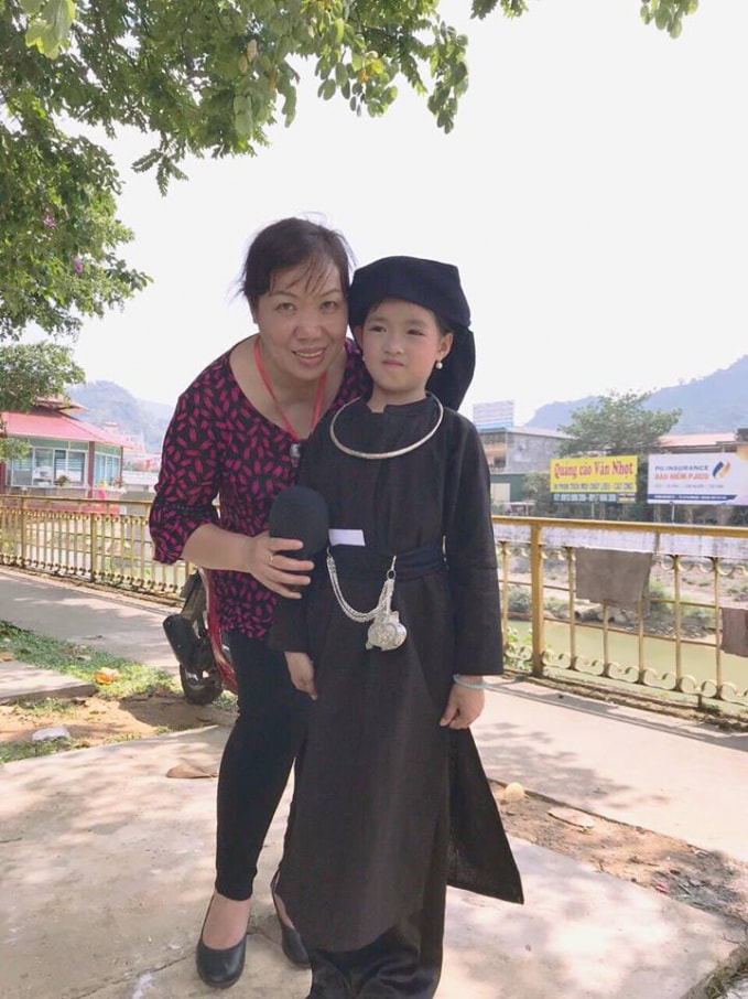 Nhà báo Hoàng Thu Thùy cùng em bé người dân tộc trong một chuyến công tác vùng cao