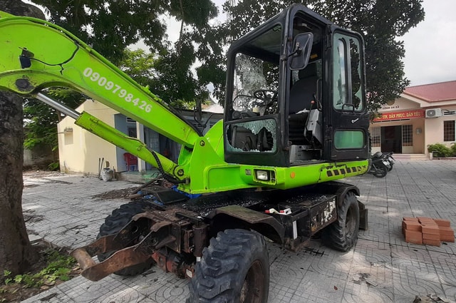 Xe cuốc của lực lượng cưỡng chế bị những người chống đối ném đá làm vở kiếng ...