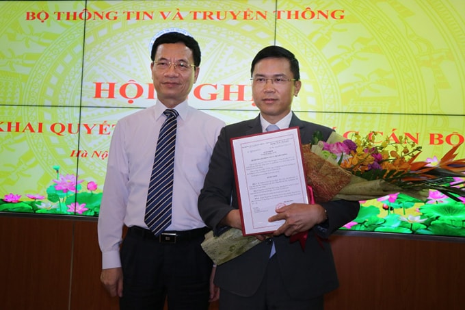Bộ trưởng TT&TT Nguyễn Mạnh Hùng trao quyết định và tặng hoa chúc mừng cho ông Phạm Anh Tuấn. Ảnh: Vietnamnet