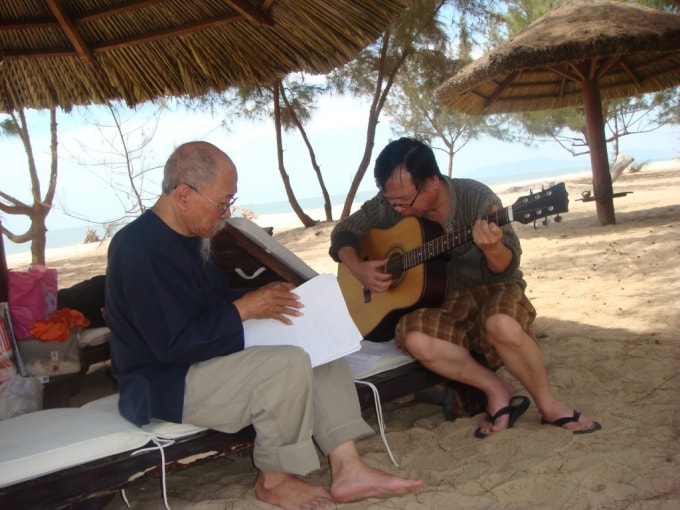 Họa sĩ Hoàng Ngọc Biên (bên trái) cùng với người bạn thân đang dạo bản nhạc mới do ông sáng tác. (Ảnh: Họa sĩ Đoàn Mẫn cung cấp).