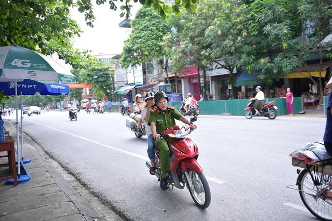 Đại úy Vũ Đức Lợi đón thí sinh Trần Thị Yến kịp giờ thi. Ảnh: Trường Phong.