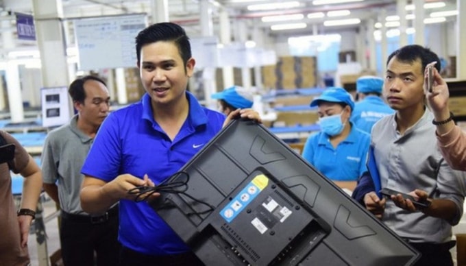 Chủ tịch Asanzo Phạm Văn Tam giới thiệu về quy trình sản xuất tivi tại nhà máy ở KCN Vĩnh Lộc chiều 23/6. Ảnh: Tuổi trẻ