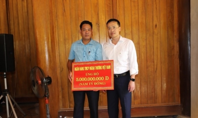 Đại diện một số doanh nghiệp, nhà hảo tâm trao tặng tiền hỗ trợ cho huyện Quan Sơn. (Ảnh: Minh Hiếu)
