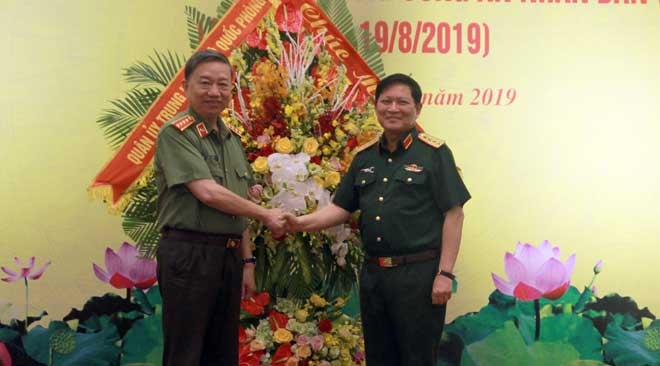 Đại tướng Ngô Xuân Lịch, Bộ trưởng Bộ Quốc phòng tặng hoa chúc mừng Đại tướng Tô Lâm, Bộ trưởng Bộ Công an. Ảnh BCA