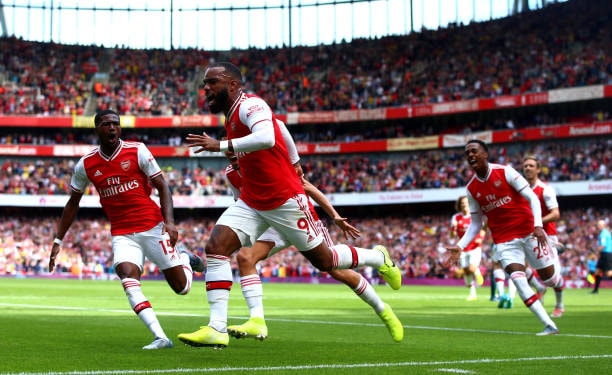 Lacazette ghi tên mình lên bảng điện tử. Ảnh: Getty