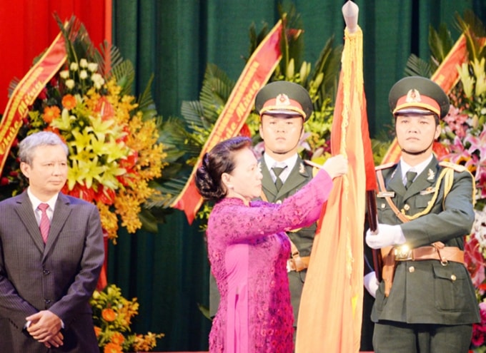 Chủ tịch Quốc hội Nguyễn Thị Kim Ngân gắn Huân chương Độc lập hạng Nhất lên cờ truyền thống của tỉnh Thừa Thiên Huế. Ảnh: PV