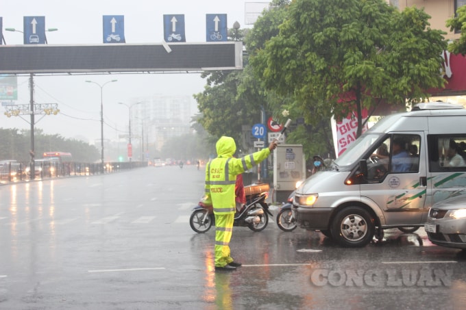 Lực lượng Cảnh sát giao thông đội mưa phân luồng giao thông, tránh ùn tắc tại khu vực bến xe Nước Ngầm