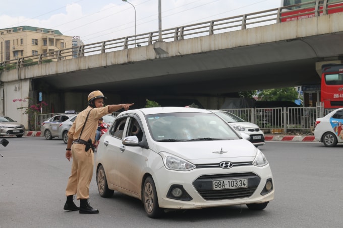Chiến sĩ CSGT Đội 6 Công An Hà Nội đang chỉ dẫn người tham gia giao thông. Ảnh Hà Long.