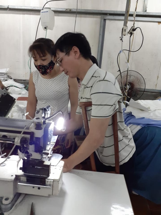 Anh Tưởng đang hướng dẫn tận tình công nhân may tại xưởng của gia đình mình. Ảnh Trần Toản.