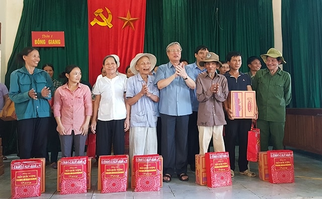 Thường trực Ban Bí thư Trần Quốc Vượng trao quà cho các gia đình chính sách, hộ nghèo ở xã Đức Giang, huyện Vũ Quang. Ảnh: NT