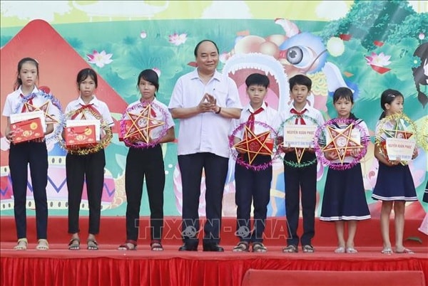 Thủ tướng Nguyễn Xuân Phúc tặng quà Tết Trung thu cho thiếu nhi xã Đại Minh, huyện Đại Lộc, tỉnh Quảng Nam. Ảnh: TTXVN