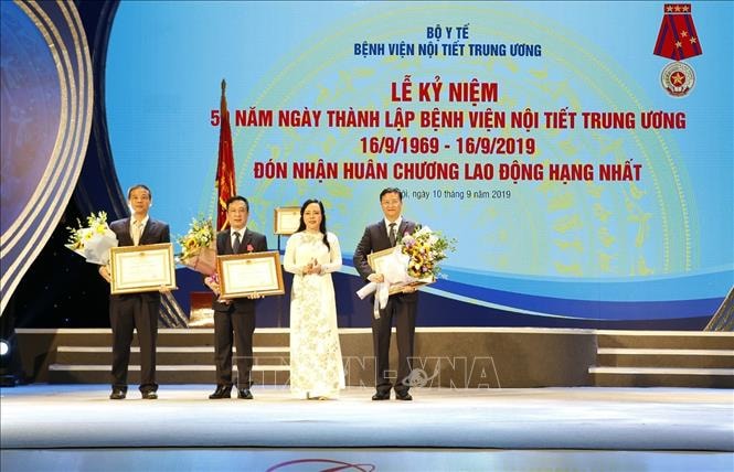 Bộ trưởng Bộ Y tế Nguyễn Thị Kim Tiến, Trưởng ban Ban Bảo vệ sức khỏe cán bộ Trung ương thừa ủy quyền của Chủ tịch nước trao Huân chương Lao động cho 1 tập thể và 2 cá nhân của bệnh viện Nội tiết Trung ương. Ảnh: TTXVN