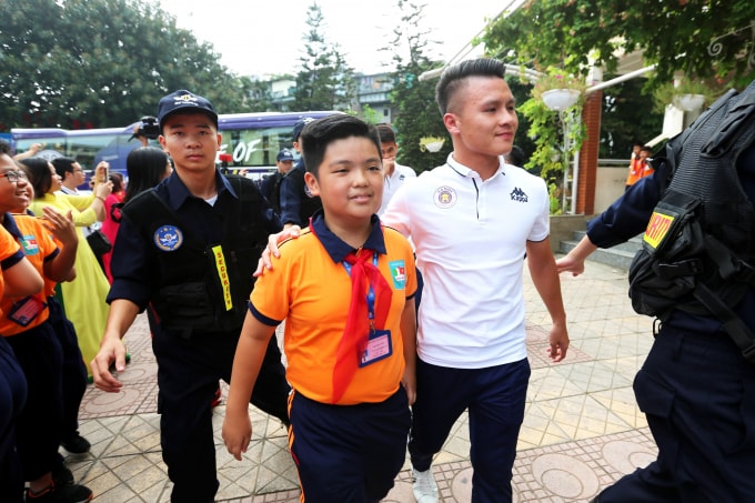Quang Hải vui vẻ bước vào cùng các em học sinh.
