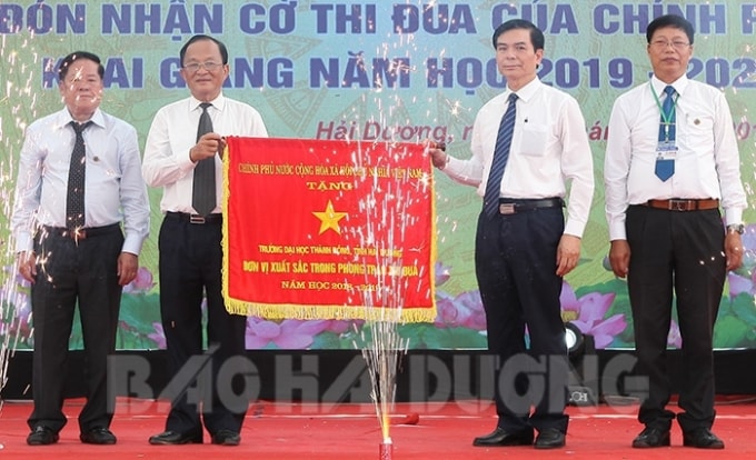 Thừa ủy quyền của Thủ tướng Chính phủ, đồng chí Vũ Văn Sơn, Phó Bí thư Thường trực Tỉnh ủy trao cờ thi đua xuất sắc cho Trường Đại học Thành Đông. Ảnh: H.D