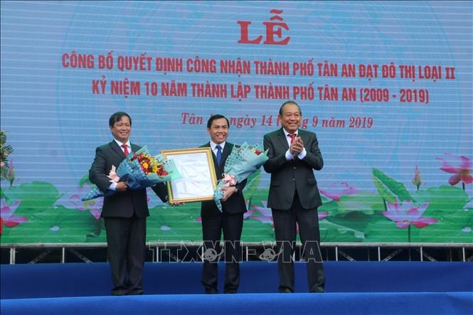 Phó Thủ tướng Trương Hòa Bình trao Quyết định công nhận thành phố Tân An đạt đô thị loại II cho đại diện lãnh đạo Thành phố. Ảnh: TTXVN