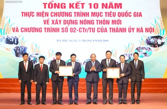 Thủ tướng trao Bằng chứng nhận đạt chuẩn nông thôn mới cho huyện Gia Lâm, huyện Quốc Oai. Ảnh: VGP