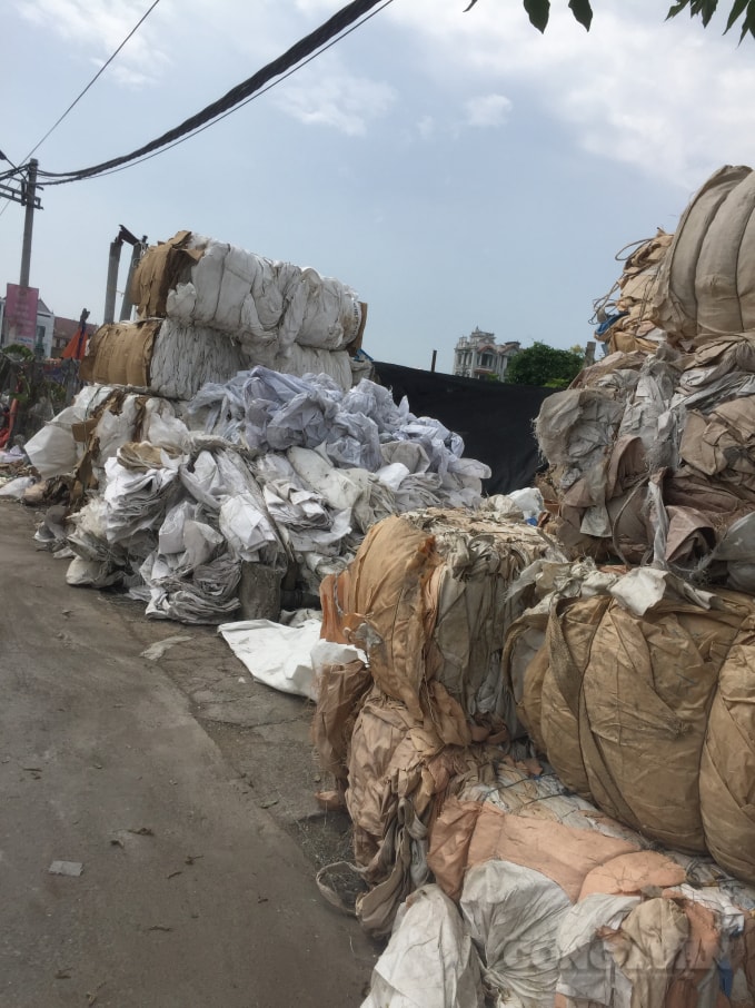 Những khối bao bì, túi ni-long cao hơn những ngôi nhà ngổn ngang hai bên đường. Ảnh : An Khang