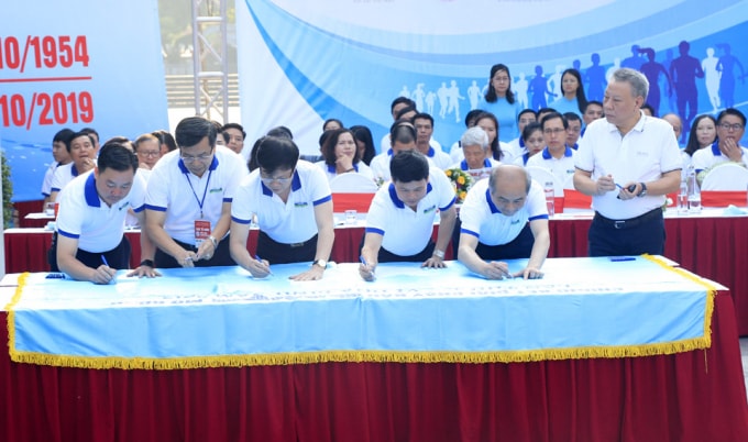Các đại biểu, khách mời và bạn bè quốc tế thực hiện nghi thức ký cờ hoà bình. Ảnh: hanoimoi