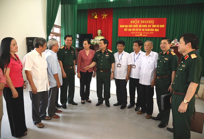 Đại tướng Ngô Xuân Lịch và các đại biểu, cử tri trao đổi bên lề hội nghị. Ảnh: BQP.