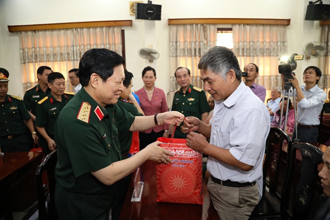 Đại tướng Ngô Xuân Lịch tặng quà các gia đình chính sách thị trấn Hòa Mạc, huyện Duy Tiên, tỉnh Hà Nam. Ảnh: BQP.
