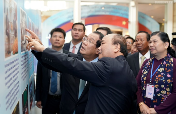Thủ tướng Nguyễn Xuân Phúc và Thủ tướng Hun Sen xem một số hình ảnh trưng bày tại Hội nghị. Ảnh: VGP