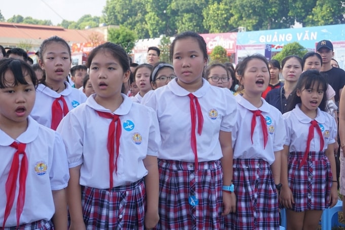 Các em học sinh của Hà Nội hôm nay trang trọng hát vang Quốc ca trong phần thực hiện nghi lễ chào cờ tại sân Đoan Môn - tại vị trí đoàn quân giải phóng thực hiện lễ chào cờ khi tiếp quản Thủ đô năm xưa. Ảnh: hanoimoi