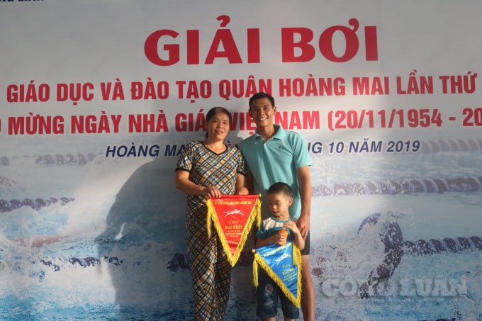 Anh Lê Văn Chinh – Giáo viên trường Định Công – Hoàng Mai vui mừng nhận giải cùng với mẹ và con trai. Ảnh: An Khang